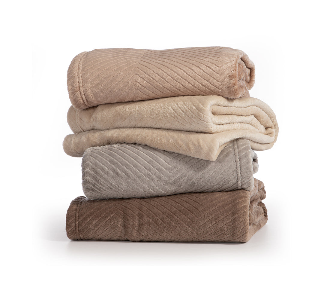 Στοίβα από ριχτάρια βελουτέ σε γήινες αποχρώσεις μπεζ, εκρού, γκρι και καφέ, διπλωμένα τακτοποιημένα με φόντο λευκό.