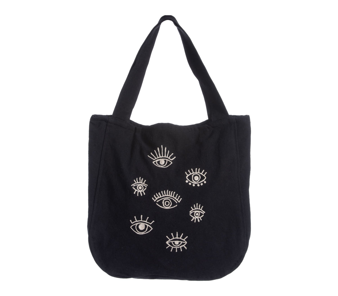 Μαύρη τσάντα θαλάσσης με φαρδιά χερούλια ώμου και σχέδιο με μάτια στο μπροστινό μέρος, τοποθετημένη σε λευκό φόντο.
