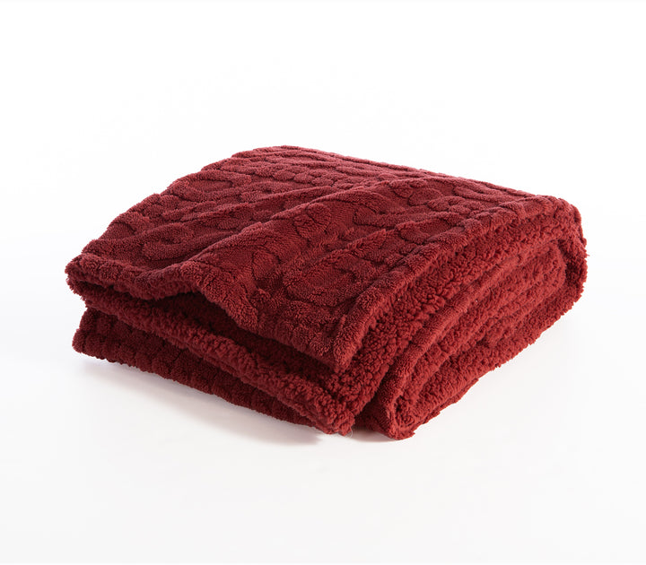 Διπλωμένο κόκκινο πολυεστερικό ριχτάρι με απαλή υφή σε λευκό φόντο.