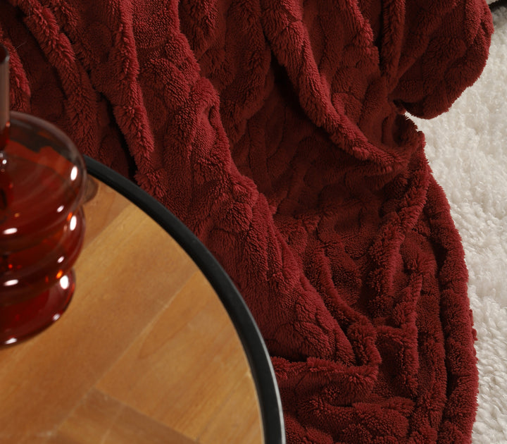 Κοντινή λεπτομέρεια κόκκινου πολυεστερικού ριχταριού με απαλή υφή επάνω σε μπεζ καναπέ.