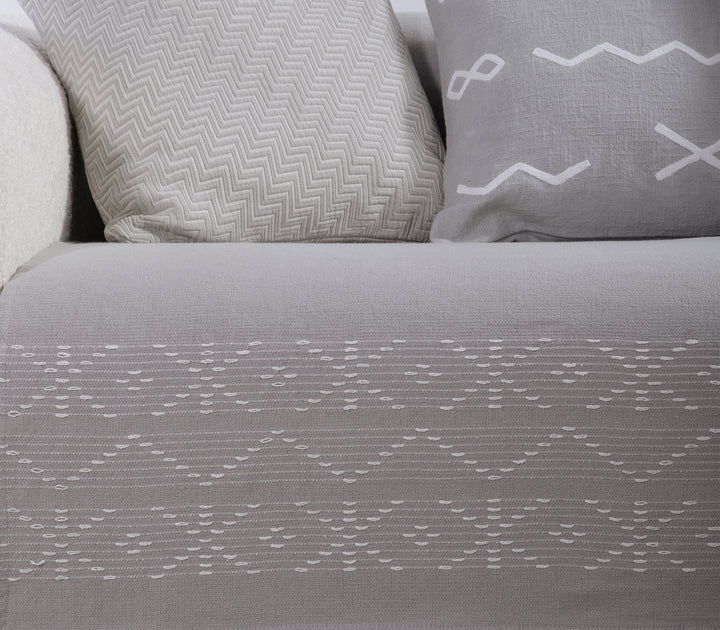 Κοντινή λήψη ριχταριού σε γκρι απόχρωση με λεπτομέρεια στο υφαντό λευκό γεωμετρικό μοτίβο.