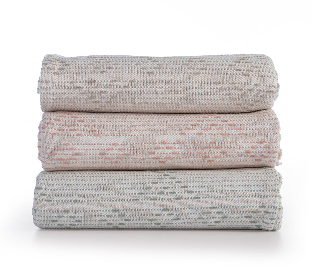 Στοίβα με τρία ριχτάρια σε μπεζ, ροδακινί και απαλό πράσινο χρώμα, με οριζόντιες ρίγες και γεωμετρικά σχέδια.