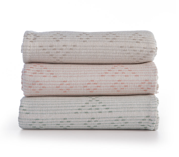 Στοίβα με τρία ριχτάρια σε μπεζ, ροδακινί και απαλό πράσινο χρώμα, με οριζόντιες ρίγες και γεωμετρικά σχέδια.