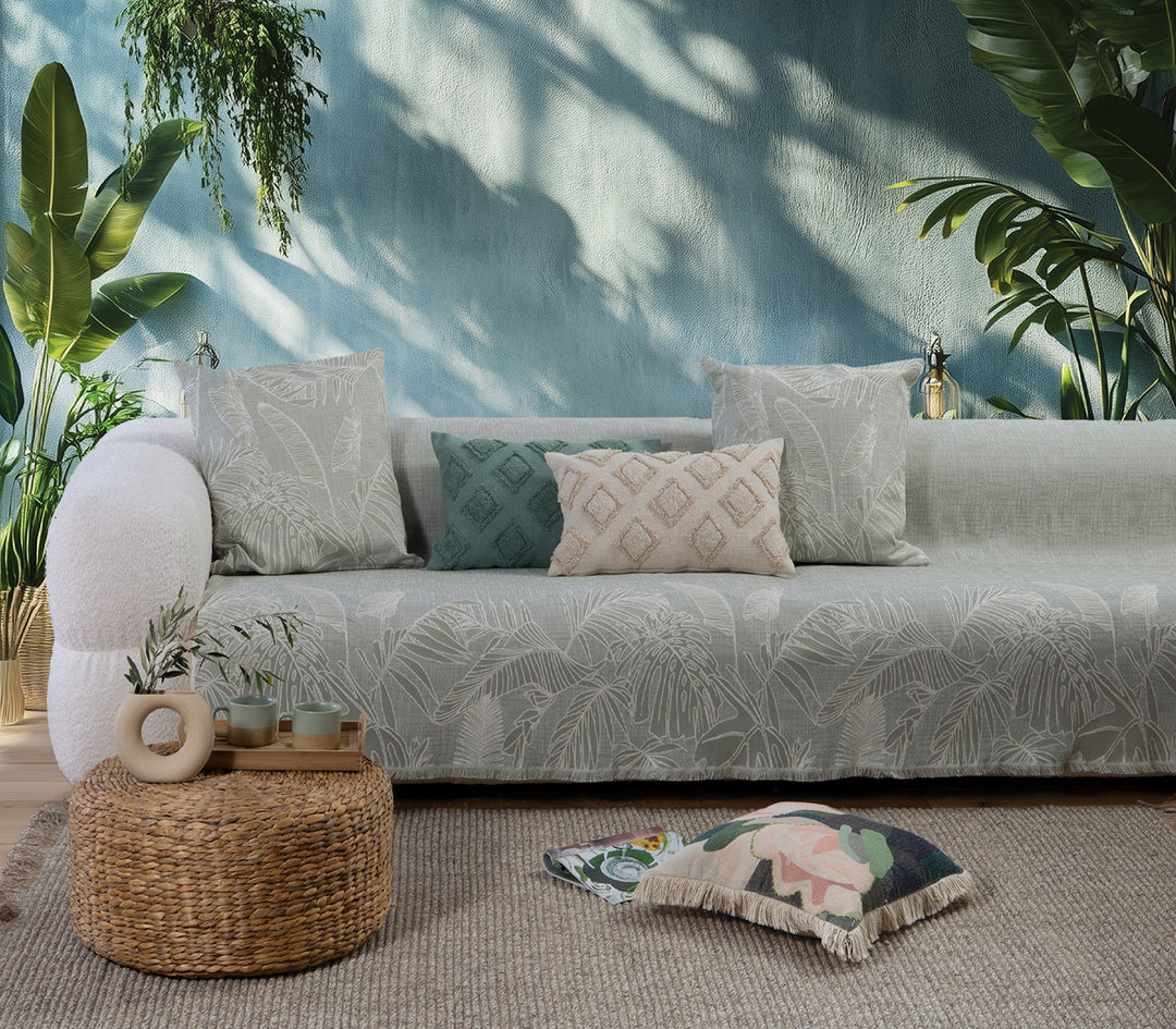 Ριχτάρι σε ανοιχτή πράσινη απόχρωση με φυτικό σχέδιο σε λευκό, στρωμένο σε καναπέ με ασορτί μαξιλάρια.