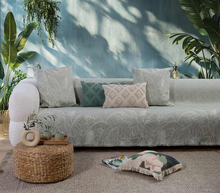 Ριχτάρι σε ανοιχτή πράσινη απόχρωση με φυτικό σχέδιο σε λευκό, στρωμένο σε καναπέ με ασορτί μαξιλάρια.
