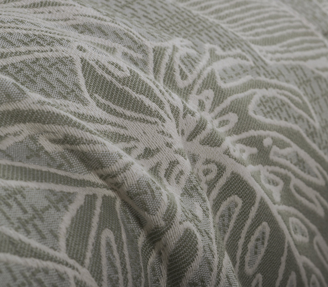 Λεπτομέρεια υφής ριχταριού σε απαλό πράσινο χρώμα με λευκά μοτίβα τροπικών φύλλων.