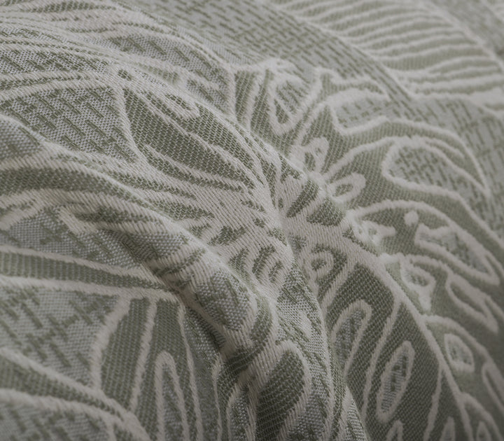 Λεπτομέρεια υφής ριχταριού σε απαλό πράσινο χρώμα με λευκά μοτίβα τροπικών φύλλων.