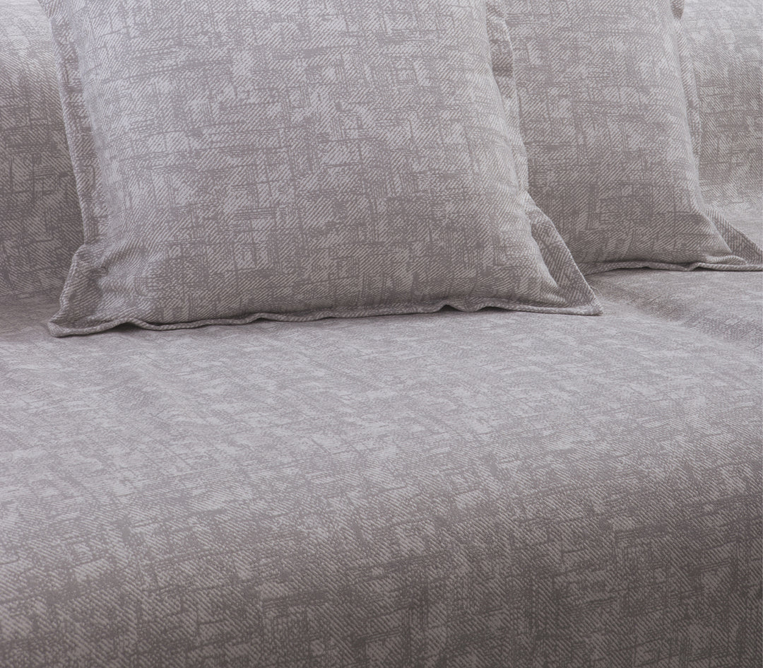 Κοντινή λήψη του ριχταριού σε ανοιχτό γκρι χρώμα με διακριτικό μοτίβο, συνδυασμένο με μαξιλάρια στο ίδιο σχέδιο.