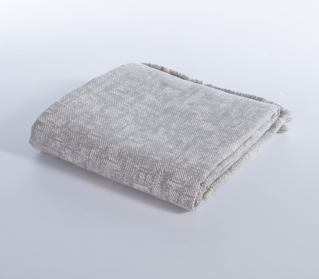 Ριχτάρι σε γκρι χρώμα με γεωμετρικό μοτίβο, διπλωμένο σε καθαρό λευκό φόντο.