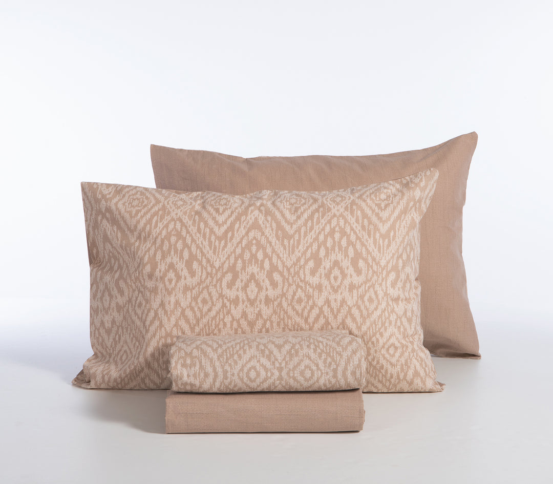Σετ σεντόνια μπεζ με γεωμετρικό σχέδιο, διπλωμένα με μαξιλαροθήκες σε λευκό φόντο.