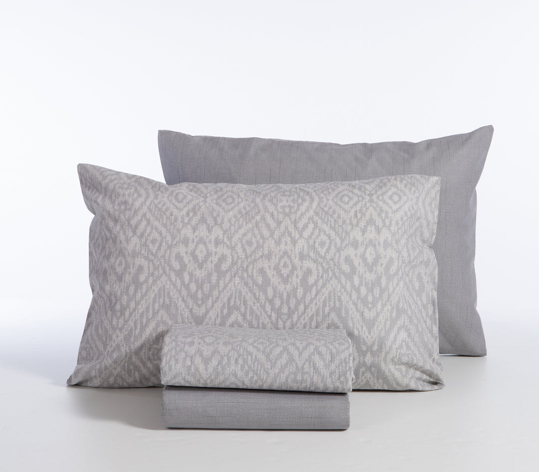 Σετ σεντόνια γκρι με γεωμετρικό σχέδιο σε λευκό φόντο, διπλωμένα με μαξιλαροθήκες.