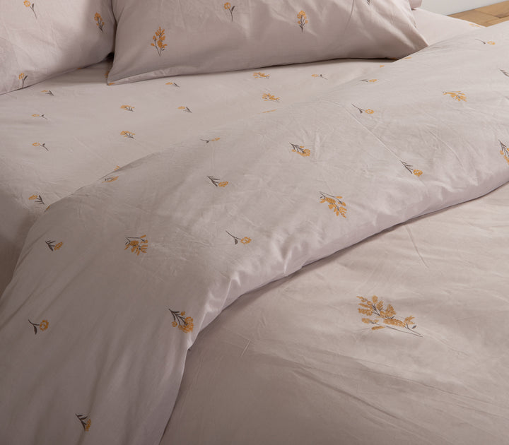 Λεπτομέρεια σε γκρι σεντόνια με κίτρινα λουλούδια, που αναδεικνύει την κομψή υφή και το λουλουδάτο μοτίβο.