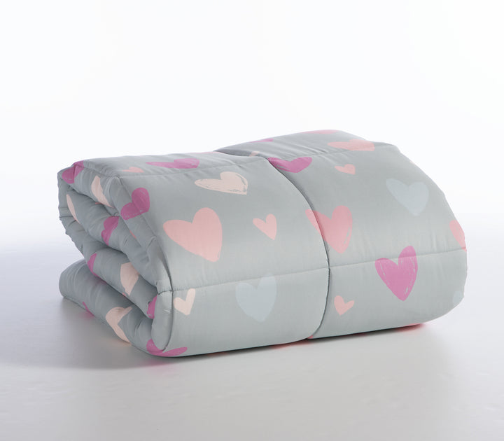 Διπλωμένο πάπλωμα παιδικού δωματίου σε μέντα χρώμα και σχέδιο καρδιές σε λευκό φόντο.
