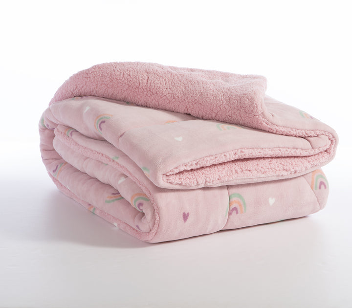 Διπλωμένο Παιδικό κουβερτοπάπλωμα σε ροζ χρώμα με σχέδιο ουράνιο τόξο σε λευκό φόντο.