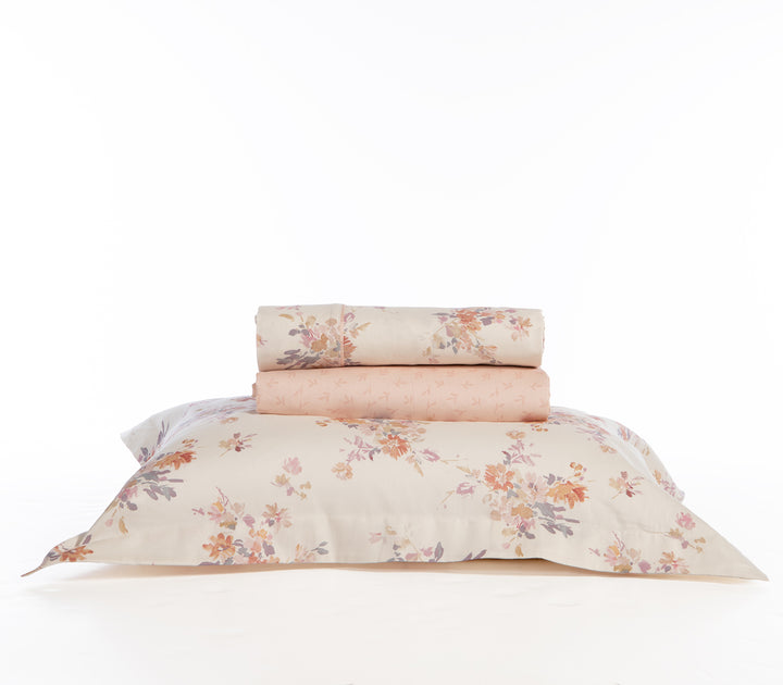 Σετ σεντόνια διπλωμένα σε λευκή βάση με λουλουδάτο σχέδιο και ροζ κατωσέντονο.