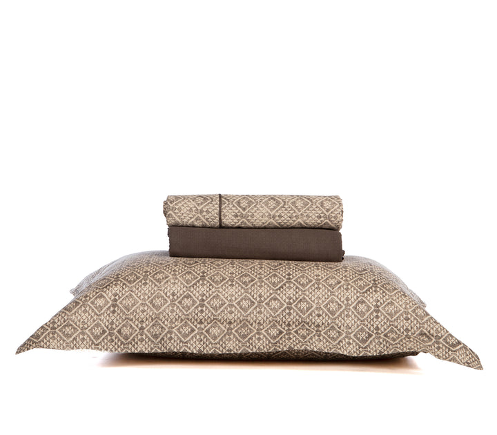 Σετ σεντόνια διπλωμένα σε καφέ και μπεζ αποχρώσεις με γεωμετρικό μοτίβο και μαξιλαροθήκη στο ίδιο σχέδιο