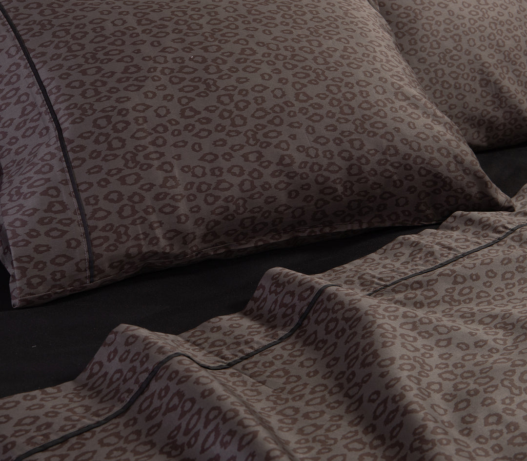 Ανθρακί σεντόνια με leopard μοτίβο και μαξιλαροθήκες πάνω σε μαύρο κατωσέντονο.