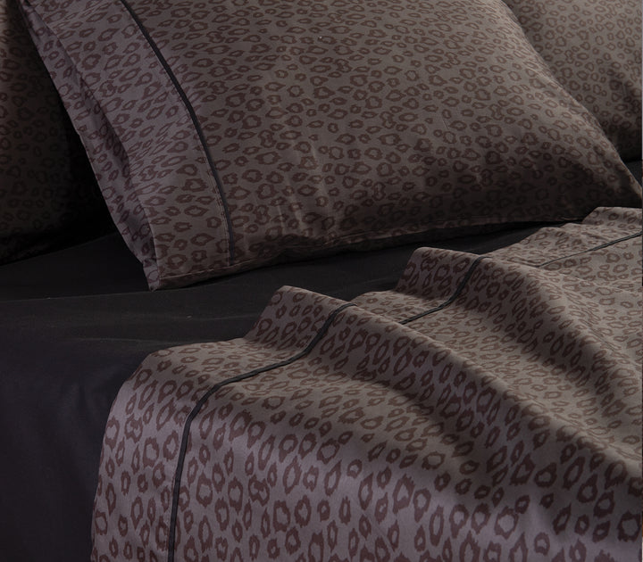 Λεπτομέρεια από μαξιλαροθήκες και σεντόνια με καφέ leopard μοτίβο σε μαύρο κατωσέντονο.