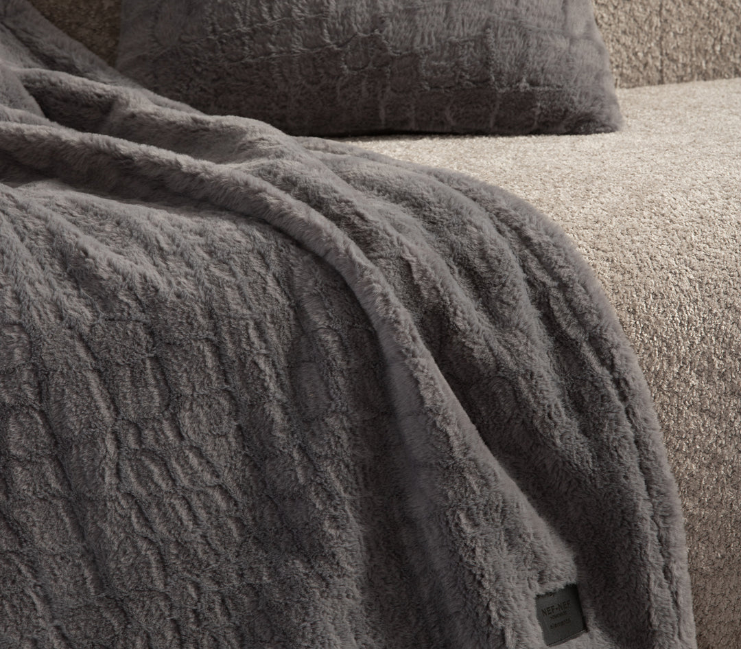 Κοντινή λεπτομέρεια γκρι κουβέρτας με απαλή υφή.