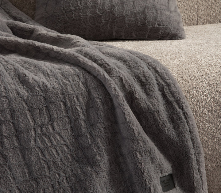 Κοντινή λεπτομέρεια γκρι κουβέρτας με απαλή υφή.