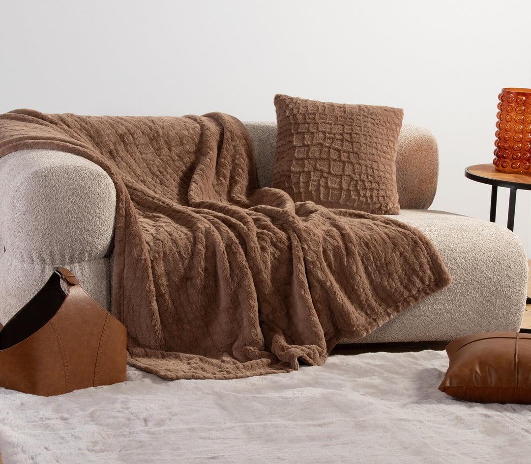 Μαύρη γούνινη κουβέρτα διπλωμένη με ανάγλυφο σχέδιο.