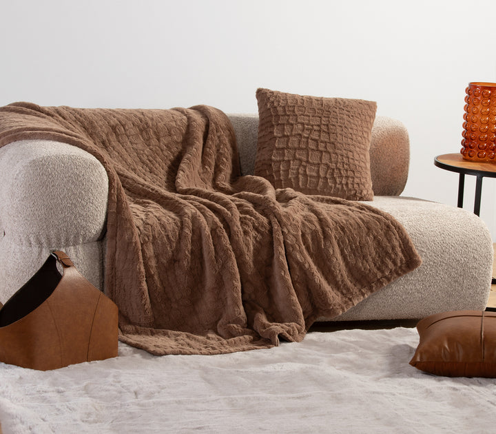 Μαύρη γούνινη κουβέρτα διπλωμένη με ανάγλυφο σχέδιο.