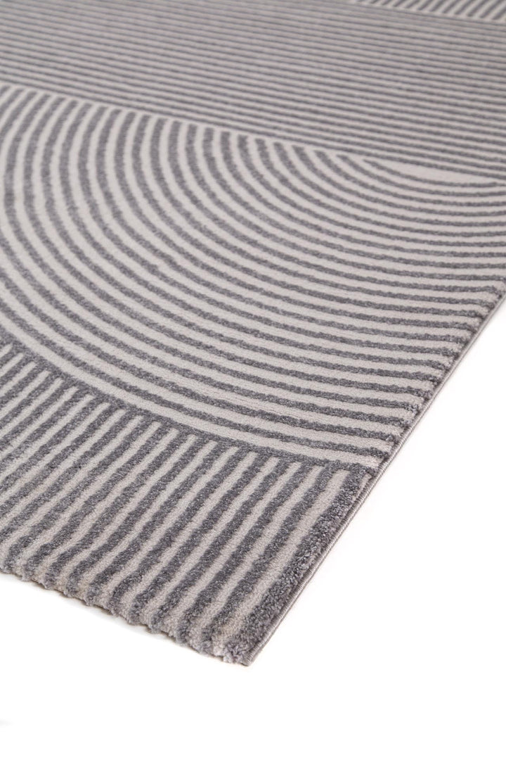 Λεπτομέρεια χαλιού Organic Royal Carpet σε γκρι-εκρού αποχρώσεις, με ανάγλυφο γεωμετρικό μοτίβο από κυκλικές και ευθείες γραμμές.