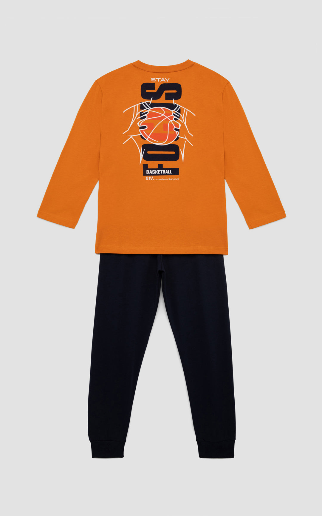 Η πίσω όψη της παιδική πιτζάμα με πορτοκαλί μπλούζα και σχέδιο μπάσκετ στο στήθος, συνδυασμένη με μονόχρωμο μπλε παντελόνι, τοποθετημένη σε απαλό γκρι φόντο.