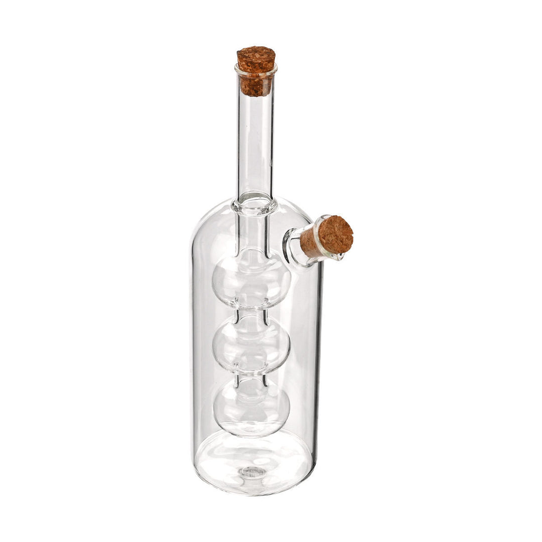 Πλάγια όψη από διάφανη γυάλινη φιάλη λαδιού με τριπλό εσωτερικό δοχείο και πώμα φελλού, σε λευκό φόντο.