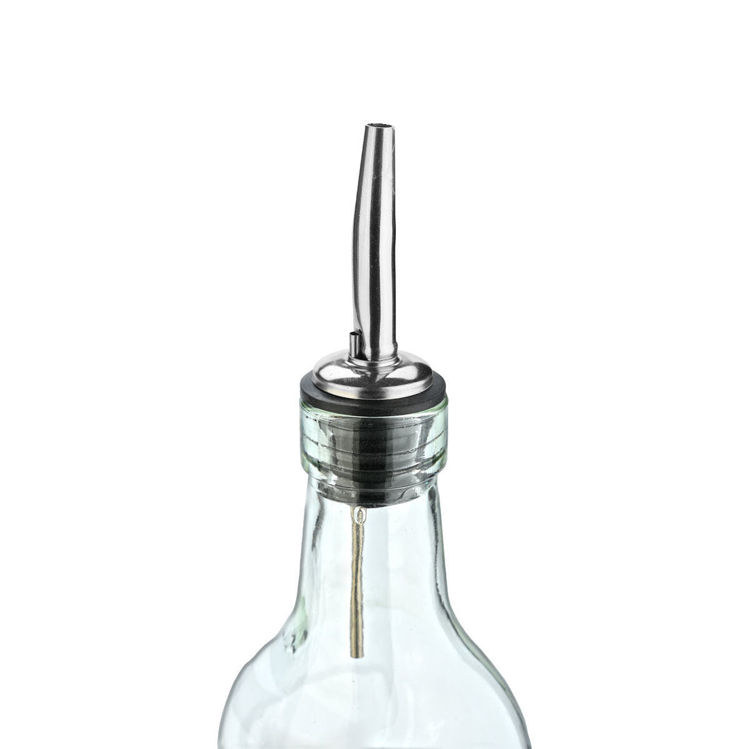 Γυάλινο μπουκάλι λαδιού με μεταλλικό στόμιο, τοποθετημένο σε πάγκο κουζίνας δίπλα σε μπαχαρικά και σκεύη.