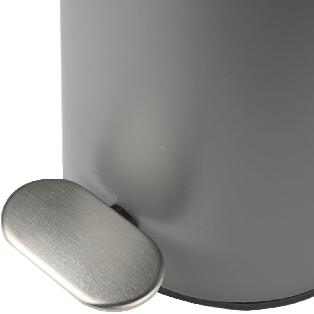 Γκρι μεταλλικός κάδος απορριμμάτων με ματ επιφάνεια και ανοξείδωτο πεντάλ, σε καθαρό λευκό φόντο στούντιο.