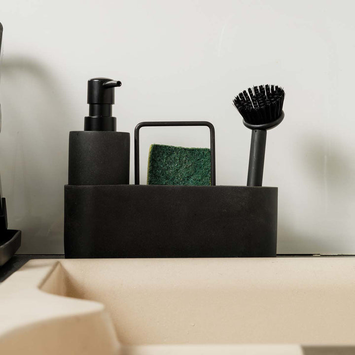 Μαύρο δοχείο υγρού πιάτων Estia τοποθετημένο δίπλα σε νεροχύτη με σφουγγάρι και βούρτσα καθαρισμού.