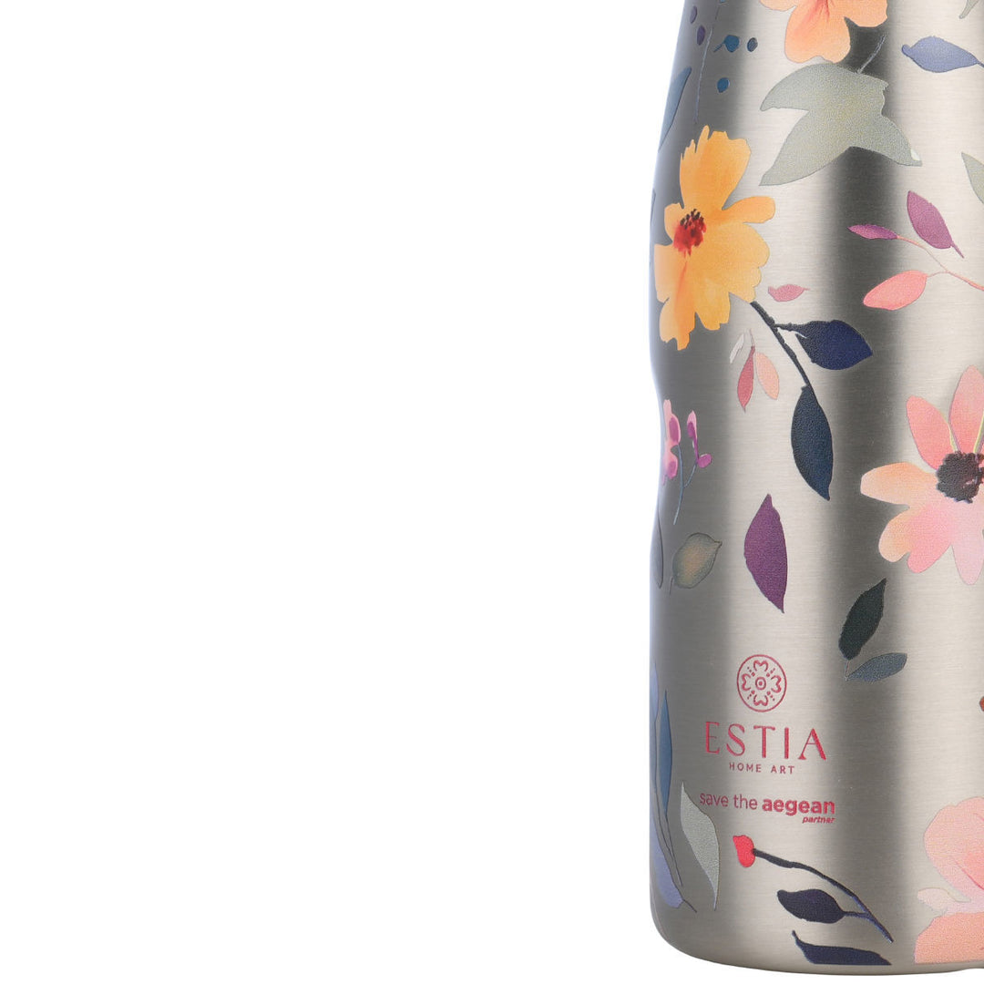 Κοντινή λήψη θερμού Estia Silver Botanic με floral μοτίβα και λογότυπο Save The Aegean σε μεταλλική επιφάνεια.