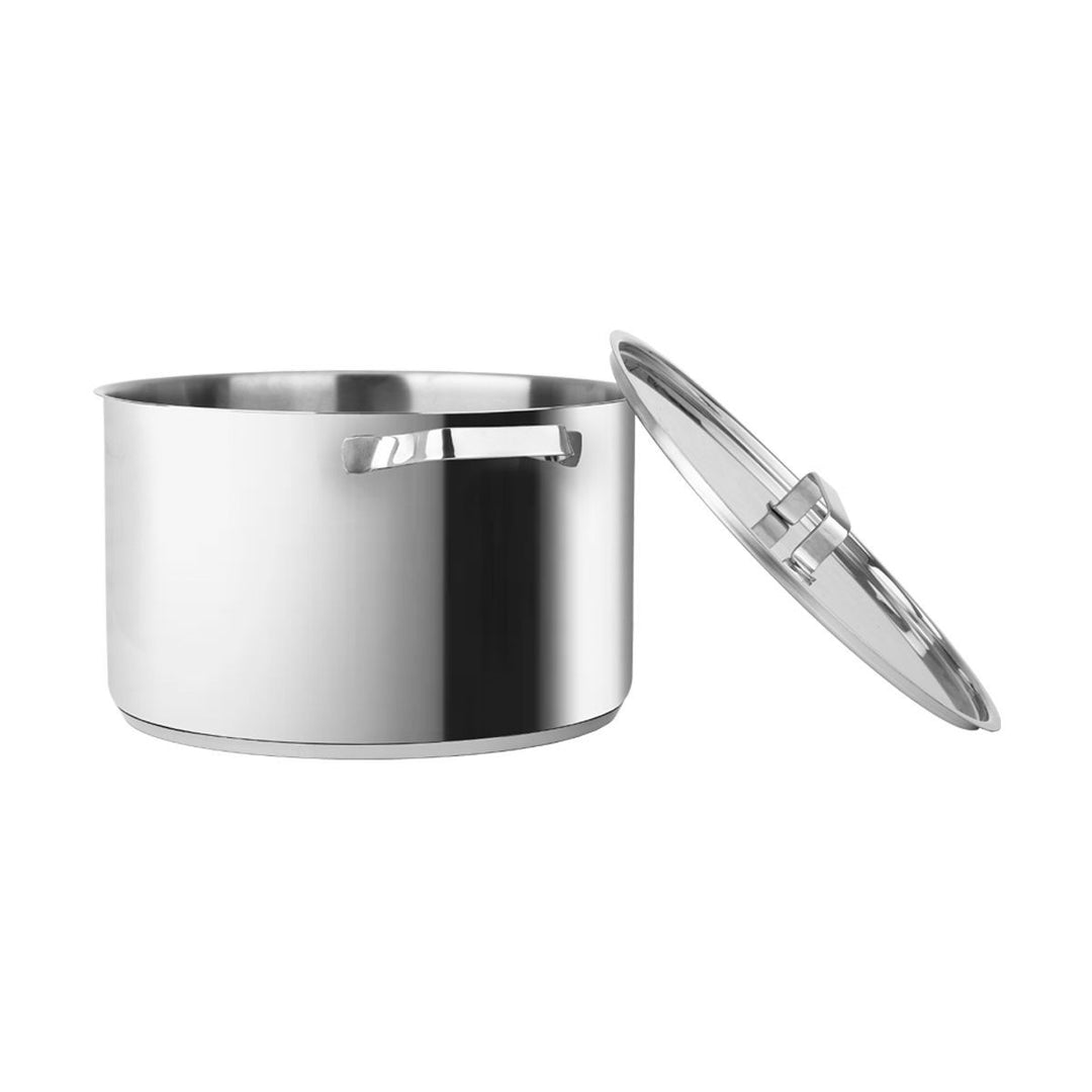 Ανοξείδωτη κατσαρόλα με γυαλιστερή επιφάνεια, εμφανίζεται με το καπάκι ελαφρώς ανασηκωμένο δίπλα της, πάνω σε λευκό φόντο.