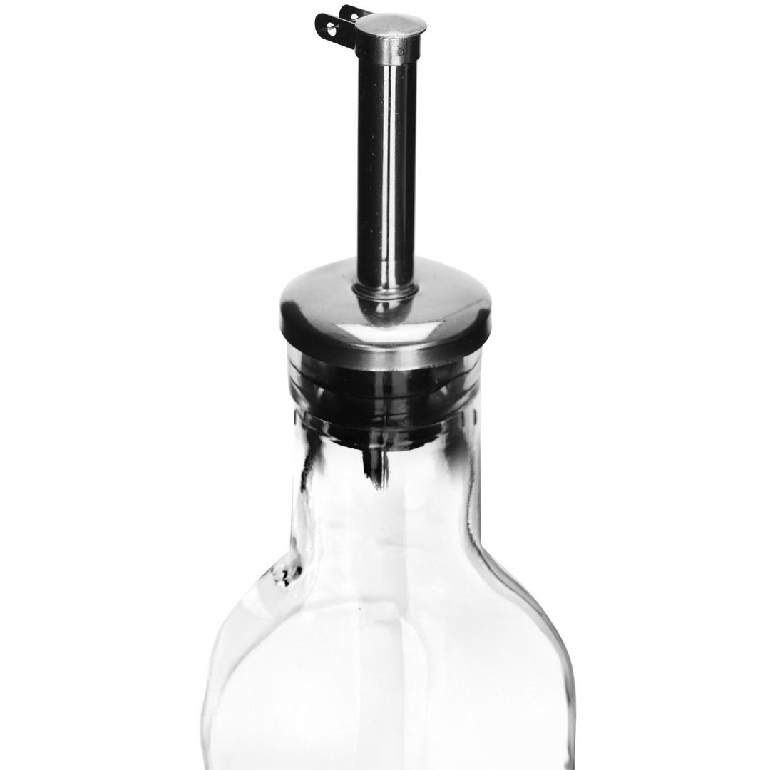 Κοντινή λήψη από διάφανο γυάλινο μπουκάλι λαδιού με μεταλλικό pourer ακριβείας και καπάκι, σε λευκό φόντο, με λιτό και κομψό σχεδιασμό για σερβίρισμα λαδιού ή ξυδιού στην κουζίνα.