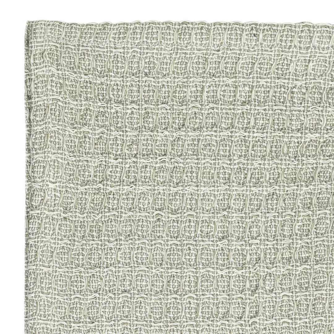 Κοντινή λήψη γκρι πετσέτας κουζίνας με ανάγλυφη υφή waffle και εμφανή πλέξη υφάσματος.