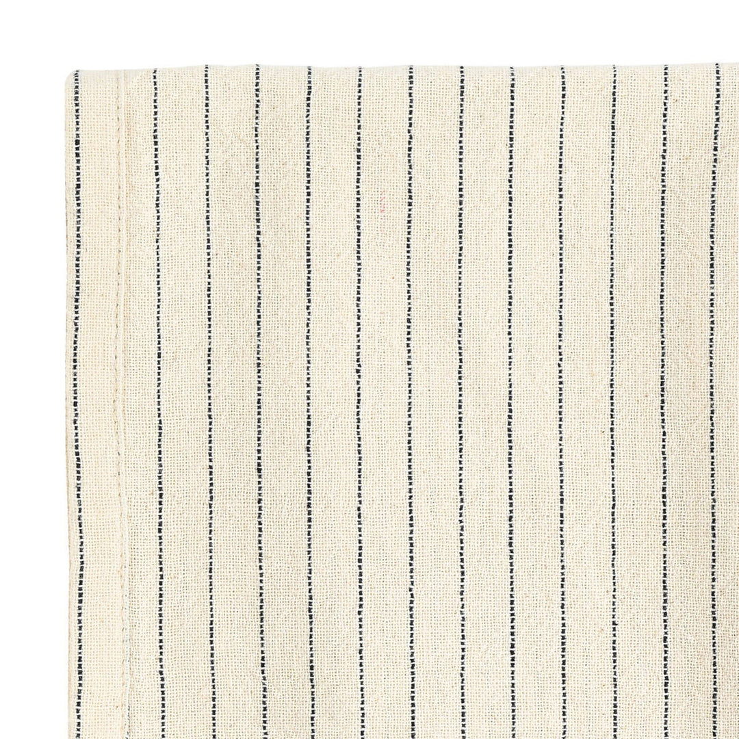 Κοντινή λήψη μπεζ πετσέτας κουζίνας με λεπτές μαύρες ρίγες και φυσική υφή υφάσματος.