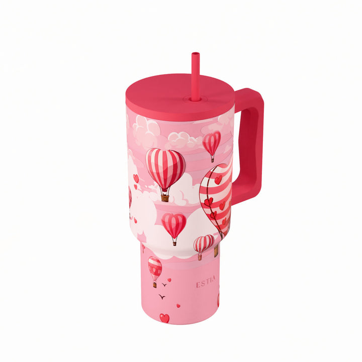 Θερμός Straw Tumbler XL Love Ascend της Estia με ροζ φόντο, αερόστατα σε σχήμα καρδιάς και καλαμάκι.