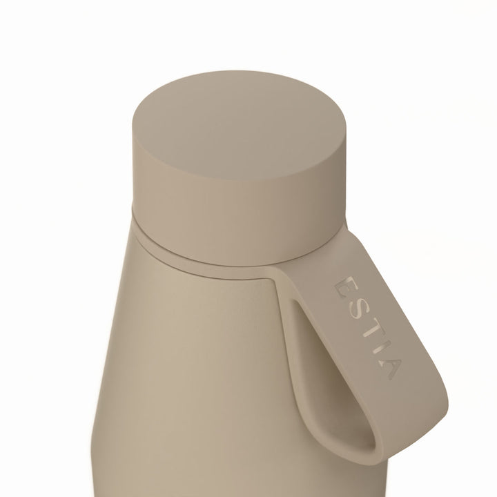 Κοντινή λήψη της βάσης του μπεζ θερμός Flow 500ml της Estia με διακριτικό λογότυπο και πληροφορίες κατασκευής.