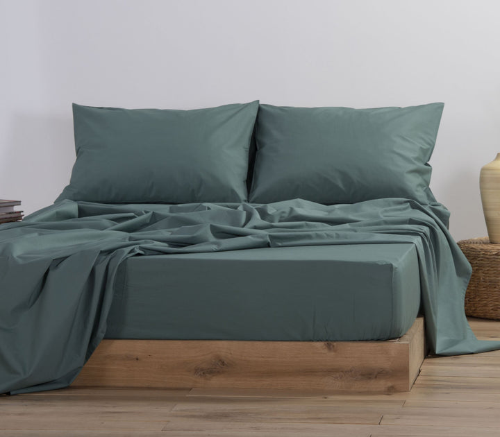 Σετ σεντονιών και αντίστοιχες μαξιλαροθήκες σε σκούρο πράσινο χρώμα, τοποθετημένο σε διπλό κρεβάτι.