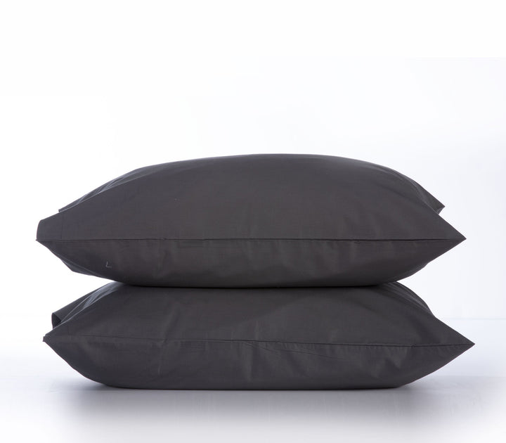 Δύο μαξιλαροθήκες σε σκούρο γκρι (dark grey) χρώμα, τοποθετημένες η μία πάνω στην άλλη, σε λευκό φόντο που δημιουργεί κομψή αντίθεση και αναδεικνύει τον μίνιμαλ σχεδιασμό τους