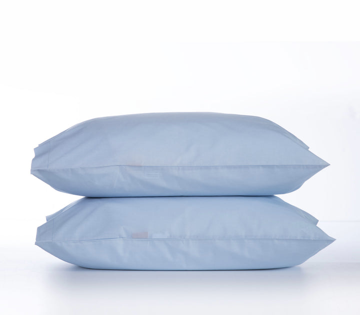 Δύο γαλάζιες μαξιλαροθήκες τοποθετημένες η μία πάνω στην άλλη, σε λευκό φόντο