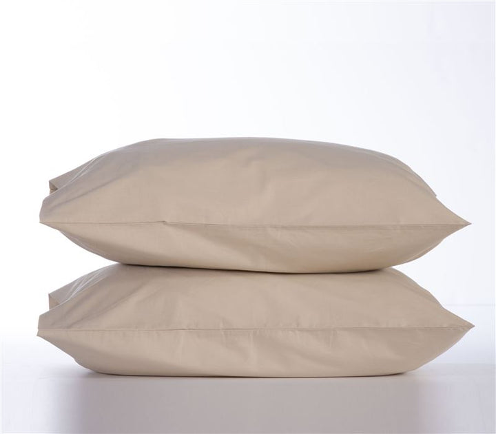 Δύο μαξιλαροθήκες σε μπεζ χρώμα, τοποθετημένες η μία πάνω στην άλλη, σε λευκό φόντο που αναδεικνύει τη ζεστή και φυσική τους απόχρωση, ιδανικές για κλασική και ουδέτερη διακόσμηση