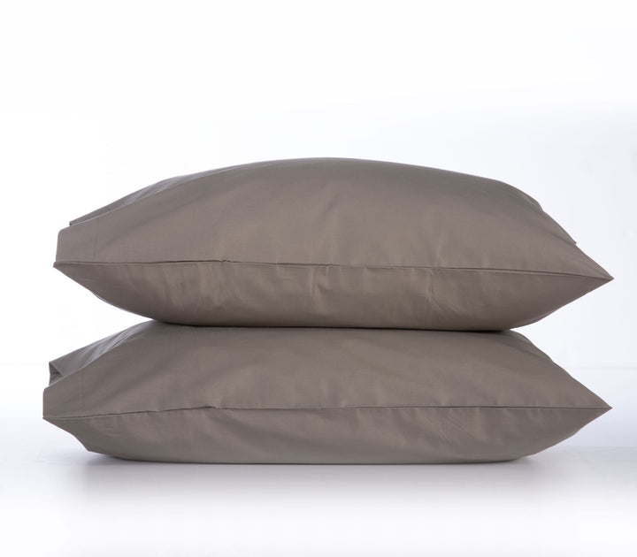 Δύο μαξιλαροθήκες σε απόχρωση μόκας, τοποθετημένες η μία πάνω στην άλλη, με φόντο λευκό για να τονίζεται η ζεστή, γήινη απόχρωση του υφάσματος – ιδανική για διακόσμηση σε φυσικούς και ουδέτερους τόνους.