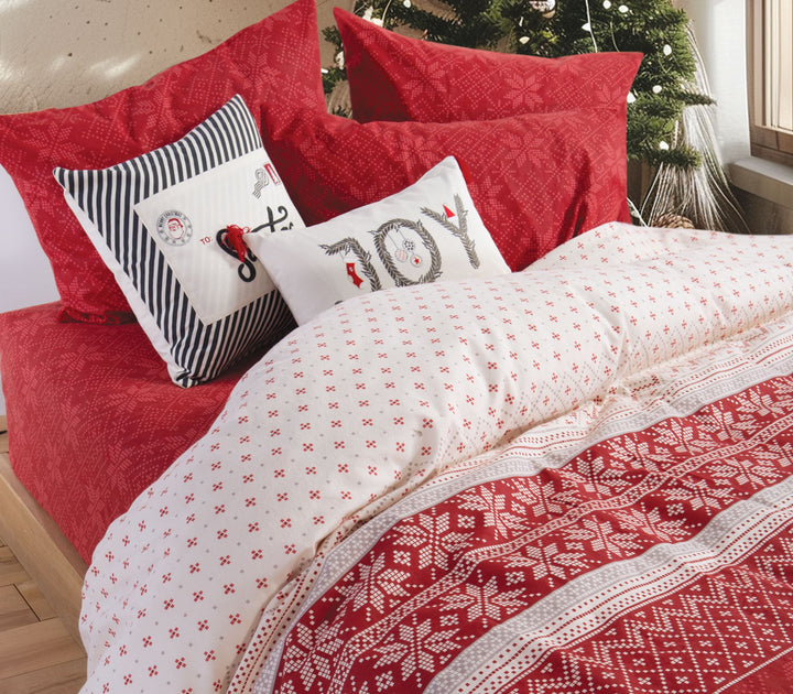 Χριστουγεννιάτικο σετ σεντόνια και παπλωματοθήκης σε κόκκινο και εκρού χρώμα με σχέδια από νιφάδες και γεωμετρικά μοτίβα, διακοσμημένο με μαξιλάρια με εορταστικά σχέδια.