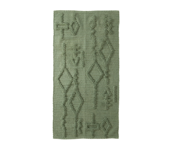 Πράσινο χαλάκι με γεωμετρικά ανάγλυφα σχέδια σε λευκό φόντο.