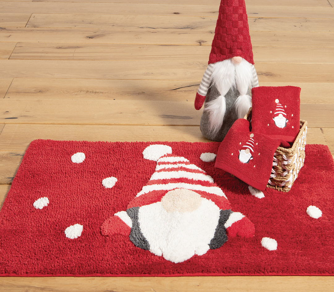 Χαλάκι μπάνιου με γιορτινό μοτίβο νάνου σε κόκκινο φόντο, συνδυασμένο με πετσέτες και διακοσμητικό στο ίδιο θέμα για χριστουγεννιάτικη διακόσμηση μπάνιου.