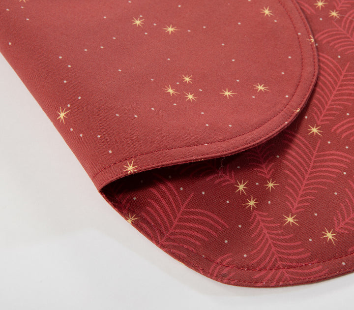Κόκκινο σουπλά σε σχήμα καρδιάς με σχέδιο χρυσά αστεράκια και διακριτικά κλαδιά, σε κοντινή λήψη που αναδεικνύει την υφή και τις λεπτομέρειες του υφάσματος.