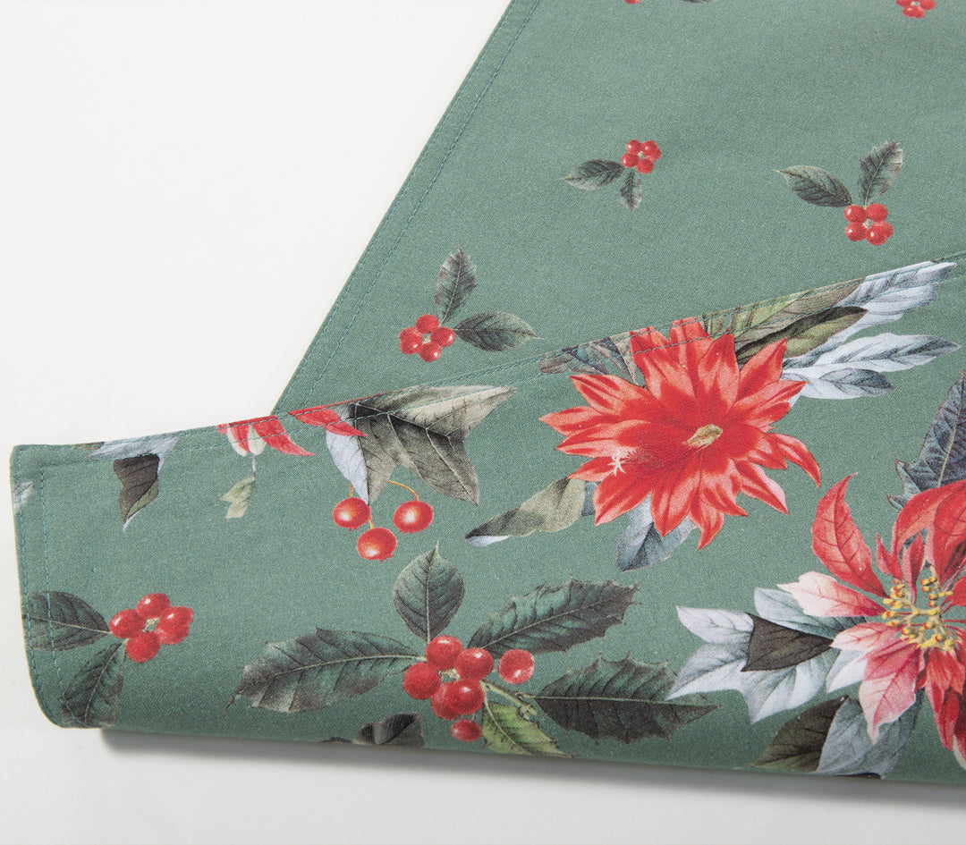Κοντινό πλάνο διπλής όψης σουπλά με γιορτινό σχέδιο, όπου φαίνονται κόκκινες αλεξανδρινές και διακριτικά μοτίβα γκι σε πράσινο φόντο.