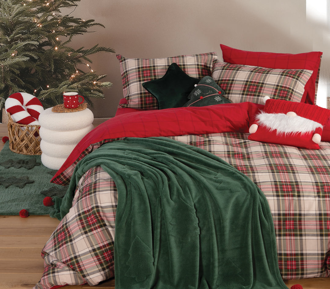 Χριστουγεννιάτικο υπνοδωμάτιο με καρό σεντόνια και πράσινη fleece κουβέρτα με ανάγλυφα δέντρα, διακοσμημένο με μαξιλάρια σε σχήμα αστεριού και Άγιο Βασίλη